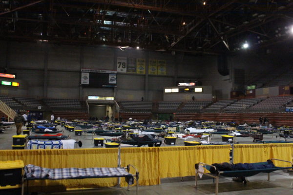 A floor of an arena with cots on the ground