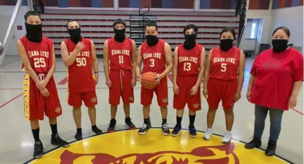 A basketball team in red wearing masks