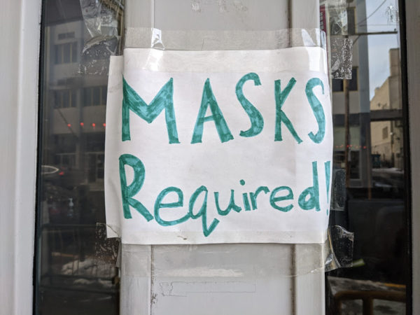 A hand-drawn sign at a downtown that says 'masks required'