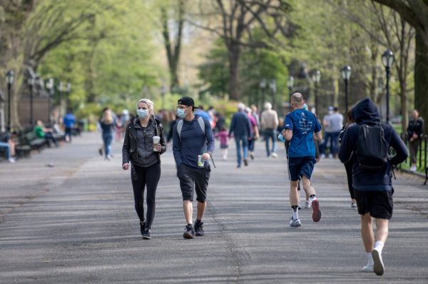 NEW YORK, NEW YORK - APRIL 25: Two people wearing masks avoid social distancing in Central Park as temperatures rose amid the coronavirus pandemic on April 25, 2020 in New York City, United States. COVID-19 has spread to most countries around the world, claiming over 200,000 lives with over 2.8 million cases. (Photo by Alexi Rosenfeld/Getty Images)