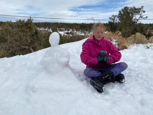 a girl sitting with a snowman buddha