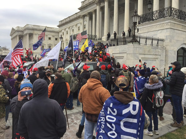 crowd with Trump banners and flags in front of Capitol