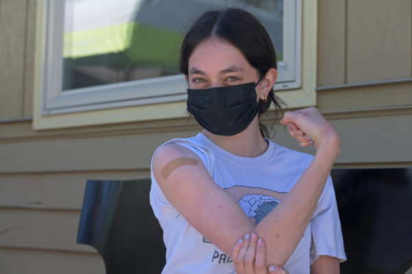 A girl flexes her muscle with bandaid