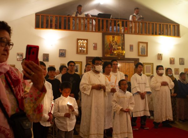 People in white robes inside a church