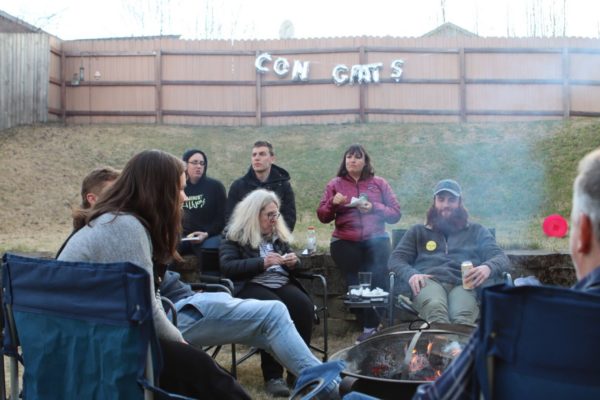 People sit around a bonfire
