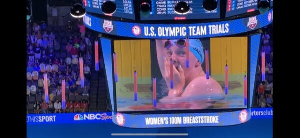 A jumbotron shows a girl in a swimming people gaspine