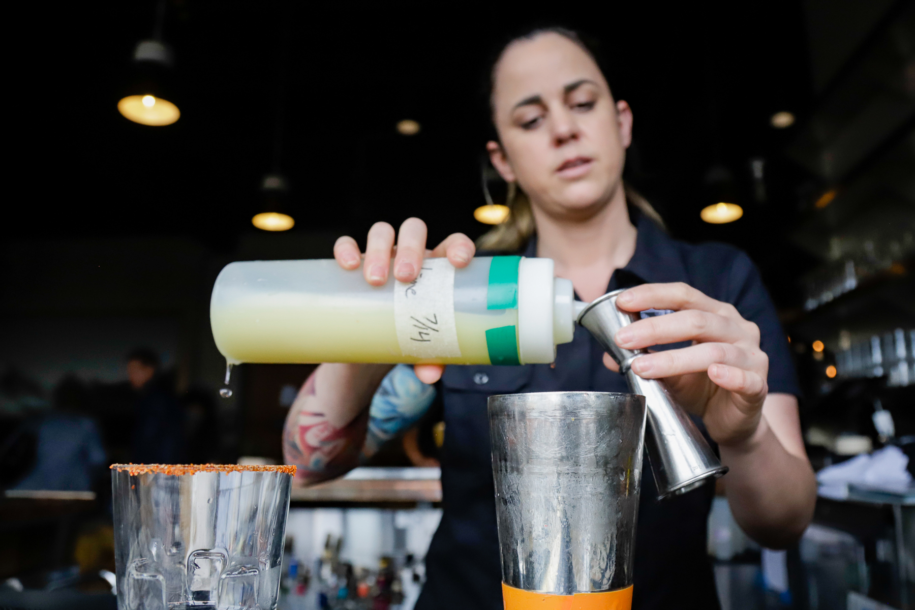 a person prepares a mixed drink at a restaurant bar