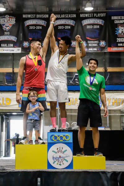 three people stand on a competition podium