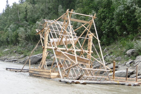 A wooden fish wheel on a large river