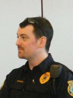 A white man with a small beard in a police uniform