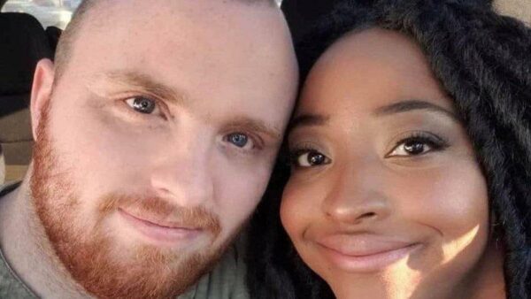 A white man with a beard and a black woman take a selfie
