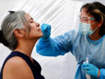 A medical assistant administers a coronavirus test to a person at Sameday Testing in Los Angeles this week.