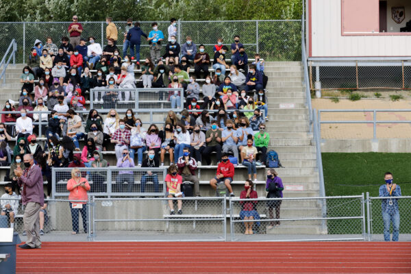 a group of people in the stands above a track & field