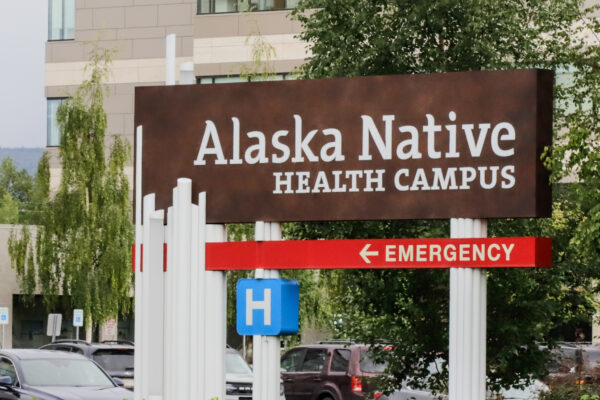 a sign in front of a parking lot and buildings that reads "Alaska Native Health Campus" and "Emergency"
