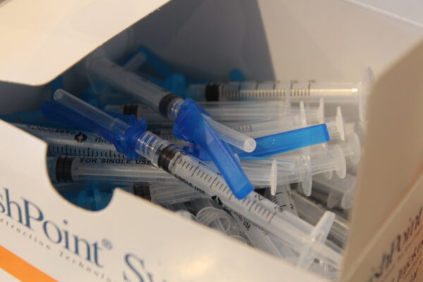 A bundle of syringes in a white box