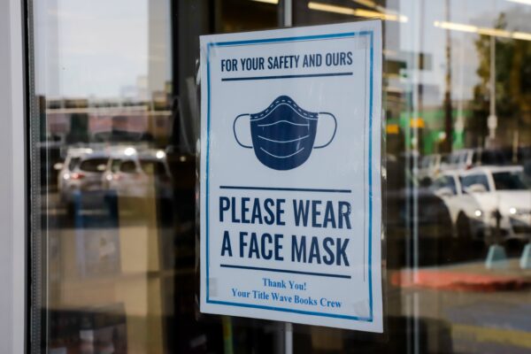  sign on a door says 'please wear a face mask'