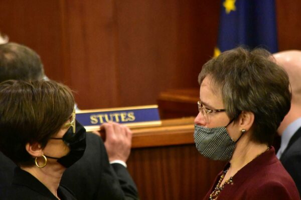 Two masked women on the floor of the state legislature