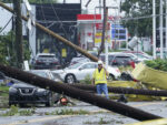 A worker stands and surveys damage as debris is strewn along West Street in Annapolis, Md., on Wednesday after severe weather moved through the area.