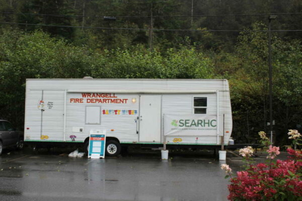 A white trailer is parked outside that says "Wrangell Fire Department" and SEARHC.
