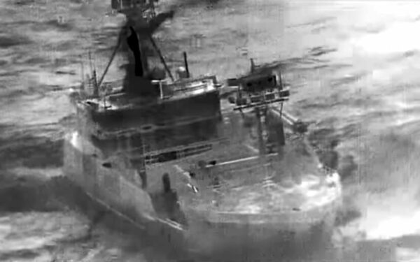 A black and white image of a boat on rough seas.