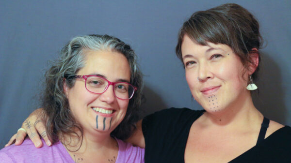 A portrait of two women with facial tattoos.