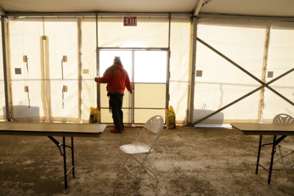 a person closes a door to a large tent