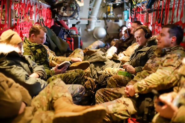 people in military uniforms sitting on a military plane