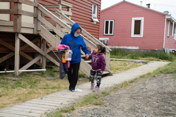 A woman and a child go on an outside walk.