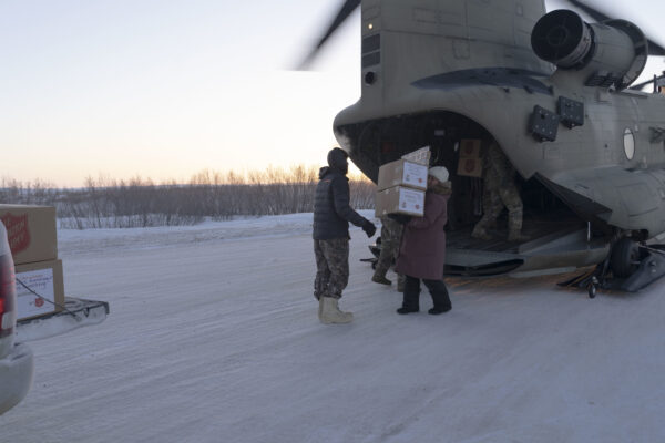 people unload gifts from a helicopter