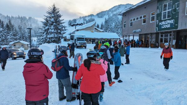 People stand in line outside at a ski area.