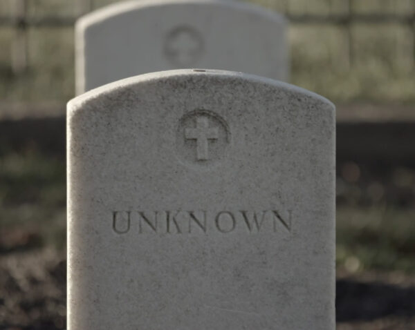 A whitish gray gravestone with a small cross and the word "unknown"