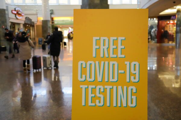 a sign that says "free covid-19 testing" at an airport