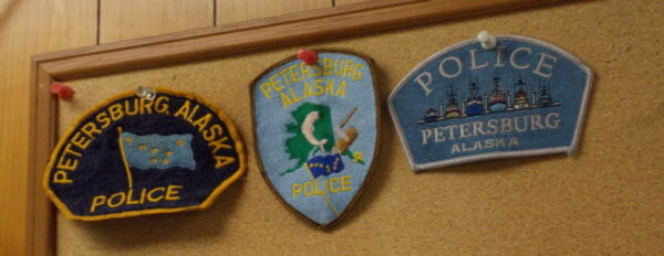 A cork board with three different patches that say 'petersburg police'