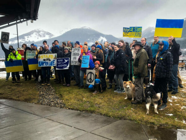 A few dozen people pose for a group photograph holding signs in support of Ukraine