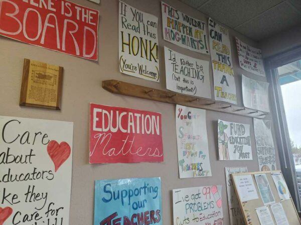 Posters with slogans like "education matters" and "supporting our teachers" hang on a wall.