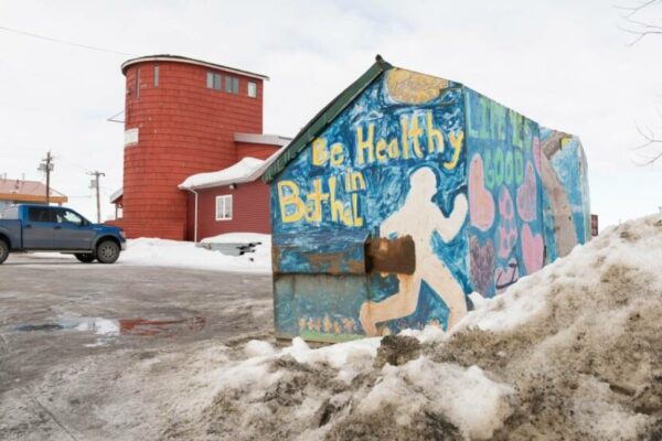 A colorful shed with the words "be healthy, Bethel" painted on it