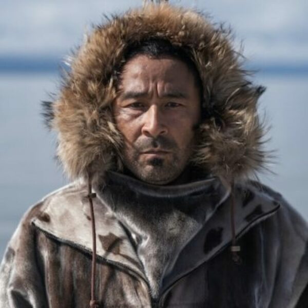 A portrait of a man standing outside in a parka