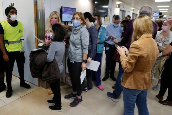 Staff volunteers queue to receive a fourth dose of the Pfizer COVID-19 vaccine at Sheba Medical Center in Israel on Dec. 27, 2021, as the hospital conducted a trial of a fourth jab of the vaccine.