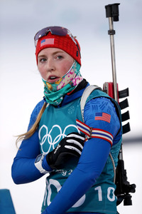 A woman in a uniform with the Olympic symbols on them