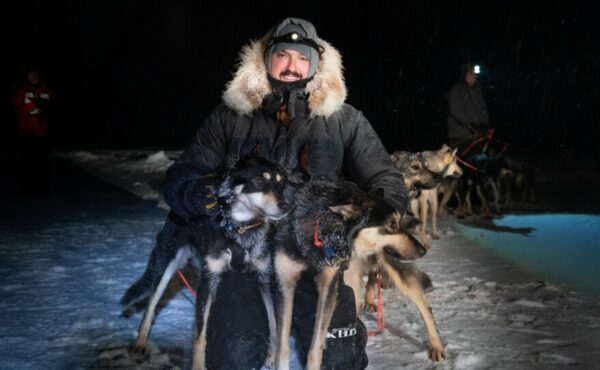 A musher poses with two dogs