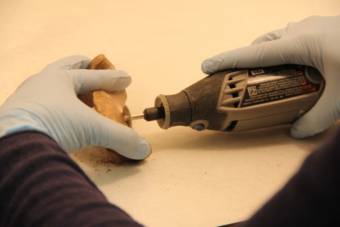 A saw cuts up fragments of a bone