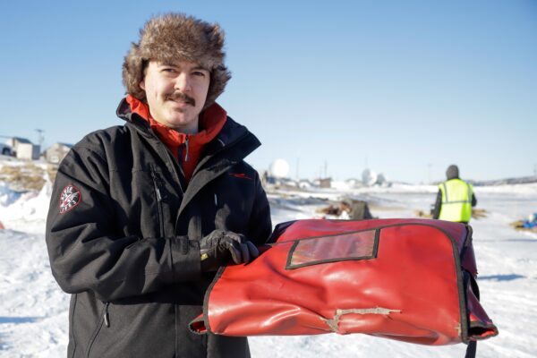 a person delivers pizza to a musher