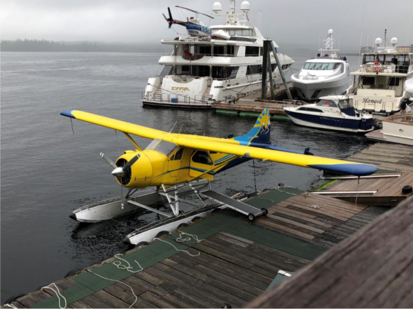 A yellow floatplane tied to a dock