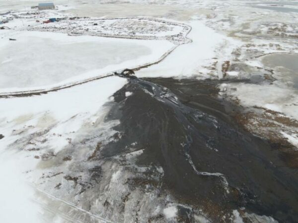 An aerial view of a plume of sewage covering a large area of snow outside a sewage lagoon