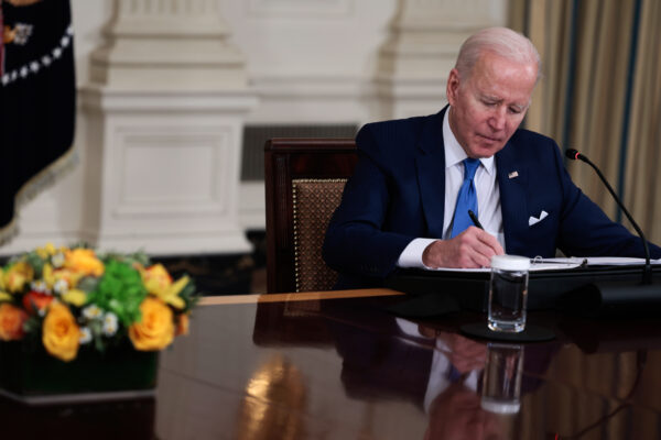 a man in a suit signing a paper