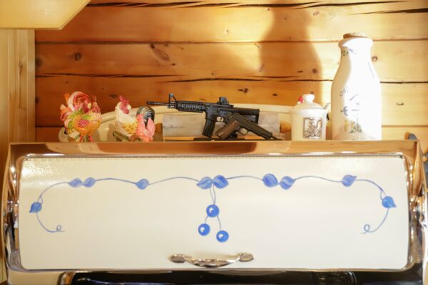 Chicken and firearm trinkets adorn the top of the stove