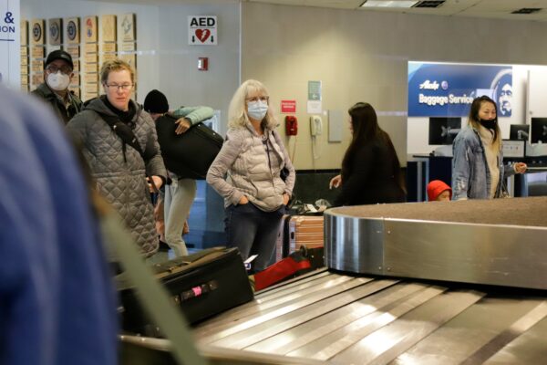 Passengers wait at a luggage gate