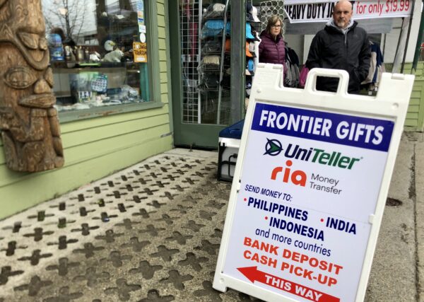 A sidewalk sign for Frontier Gifts advertising money transfers to India, Indonesia and the Philippines