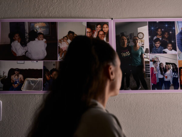 a woman looks at photos on the wall