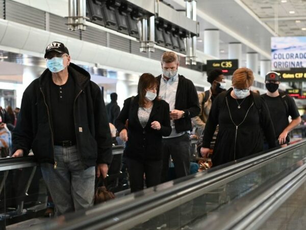 travelers at an airport wearing masks